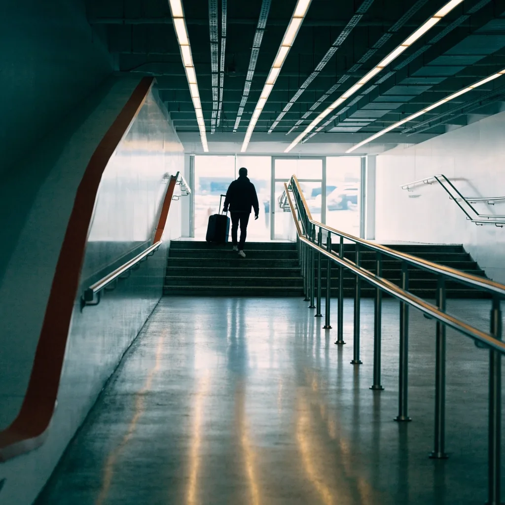 Stairwell inside terminal car park with traveller heading to doors